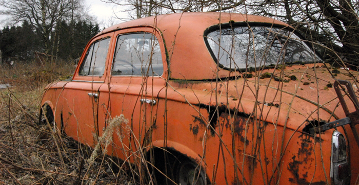 En orange gammal övergiven bil